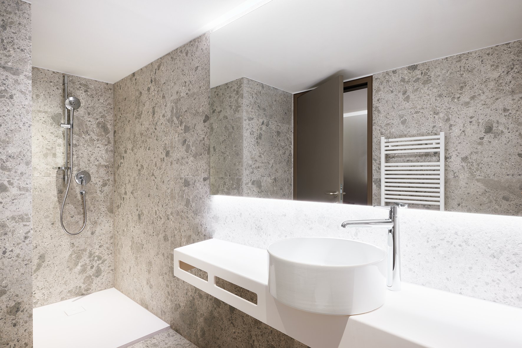 hotel bathroom with bespoke countertop, rounde washbasin, chrome faucet and shower