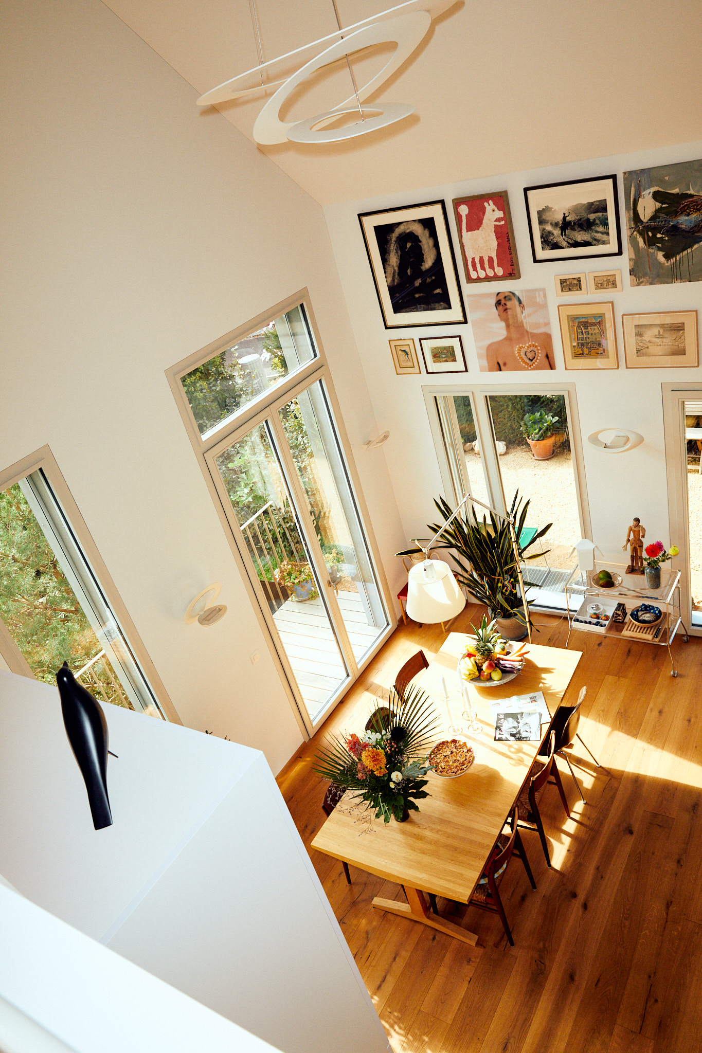Esszimmer mit großem Tisch, Stühlen, Bilder an der Wand, alles aus einer Perspektive von Oben fotografiert