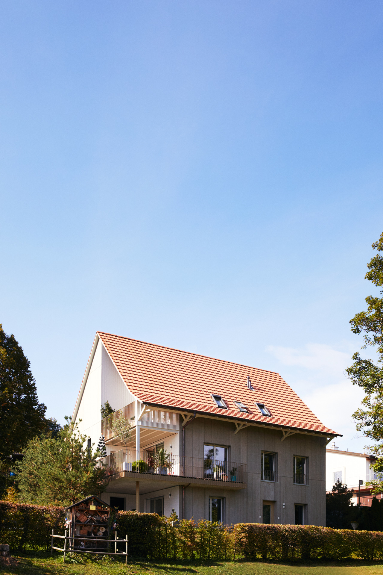 Großes, 2-stöckiges Haus im Grünen mit blauem Himmel