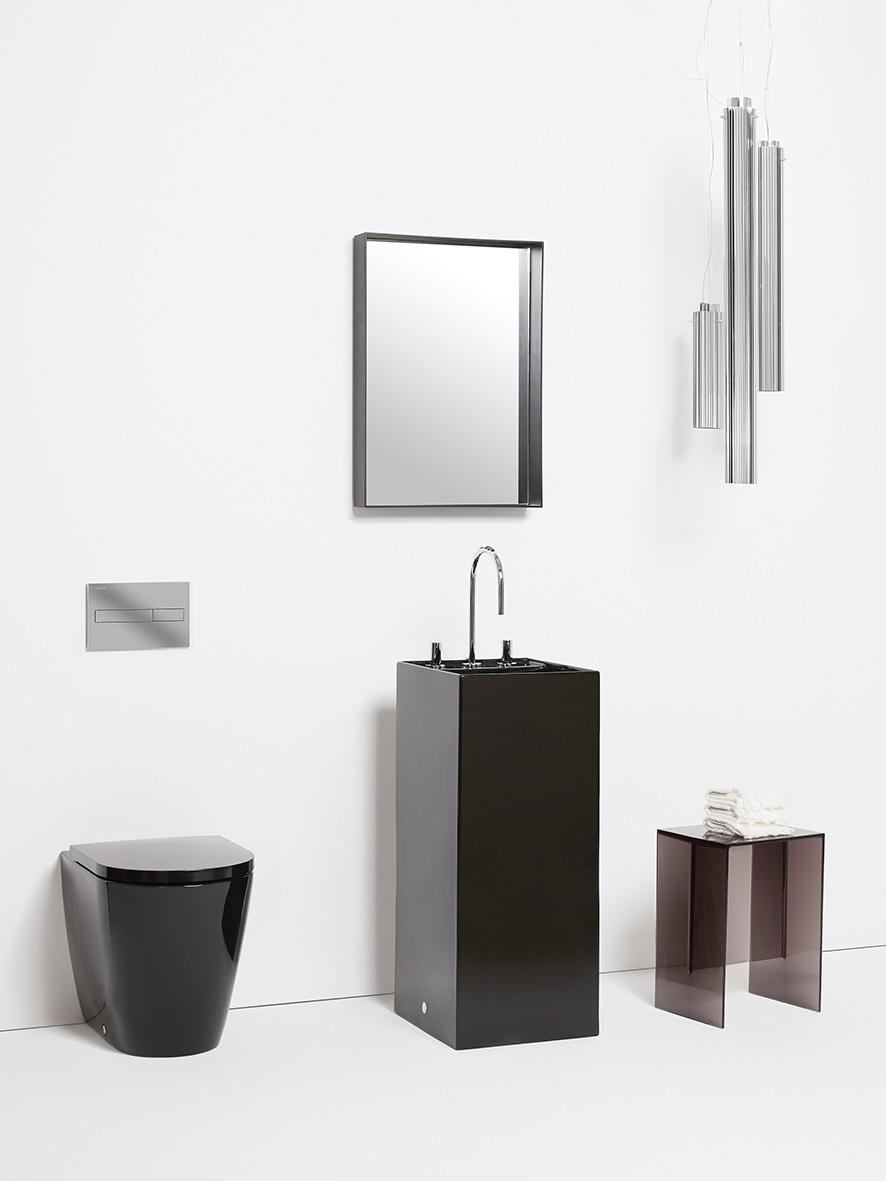 Schwarz-weißes Badezimmer mit schwarzem Stand-WC, schwarzem bodenstehenden Waschtisch und gerahmtem Spiegel, schwarzem Hocker und Wandleuchten