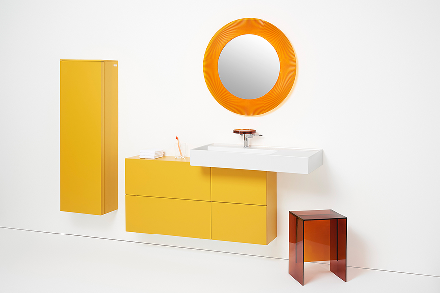 Badezimmer Set mit weißem Waschtisch, orange-farbenem Unterschrank und Hochschrank, orange-farbenem rundem Spiegel und braunem Hocker
