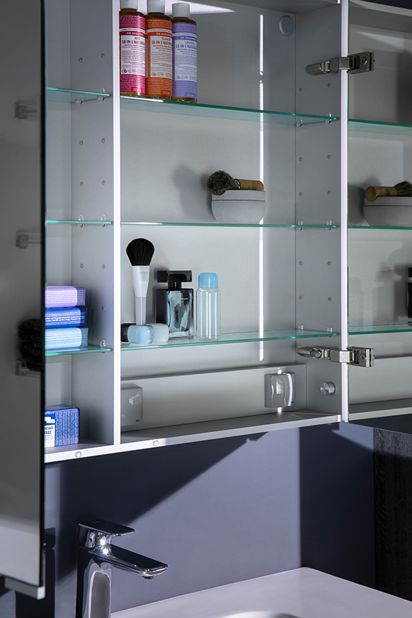 Das Innenleben von einem Spiegelschrank mit Makeup Accessories, Creme, darunter Waschtisch mit Armatur